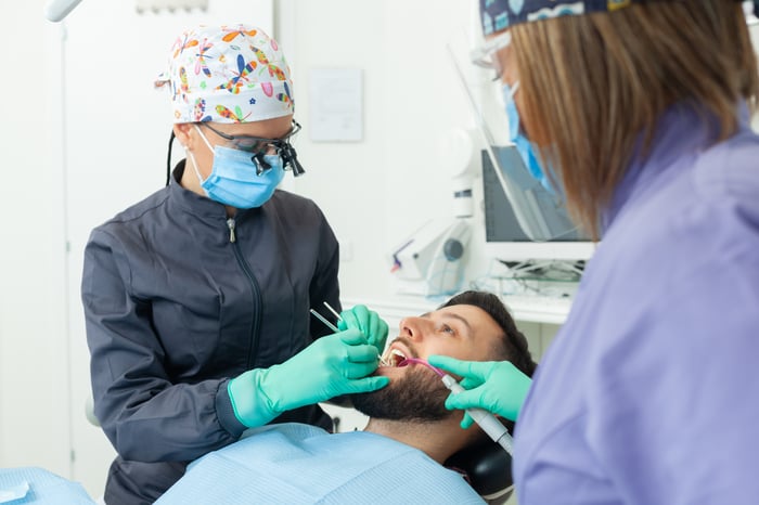 female-dentist-examines-a-man-patient-in-a-dental-2023-11-27-04-53-28-utc
